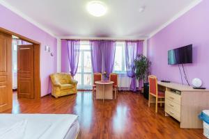 a bedroom with purple walls and a desk and chair at Hotel & Motorest V Údolí Zlatého potoka in Blšany
