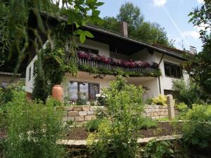 a white house with flowers on the balcony at Ferienwohnung Sonja in Edeldorf