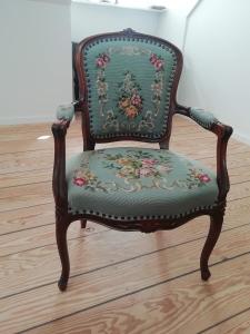 an ornate chair with a green seat with flowers at LatterLy Apartments in Voel