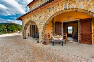 a stone house with a table and chairs on a patio at Il Grottino di Saturnia in Saturnia