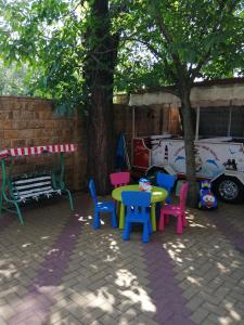 ゲレンジークにあるГостевой дом Асиятの木の下にテーブルと椅子のあるパティオ