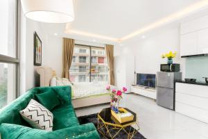 ein Wohnzimmer mit einem grünen Sofa und einem Bett in der Unterkunft DOWNTOWN#Luxury Studio1BR #Pool 16th in Ho-Chi-Minh-Stadt