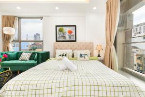 ein Schlafzimmer mit einem Bett und einem grünen Sofa in der Unterkunft DOWNTOWN#Luxury Studio1BR #Pool 16th in Ho-Chi-Minh-Stadt
