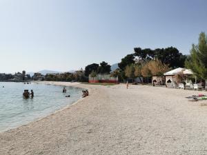 een groep mensen in het water op een strand bij Apartment Kaštilac in Kaštela