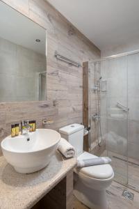 a bathroom with a sink and a toilet and a shower at Oasis Apartments in Tolo +82 photos
