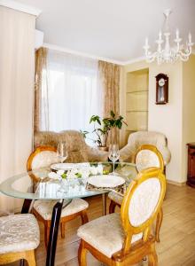 comedor con mesa de cristal y sillas en Apart Reserve Sloboda Suite, en Ivano-Frankivsk