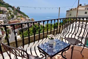 a table and chairs on a balcony with a view of the ocean at Gema Suites in Positano
