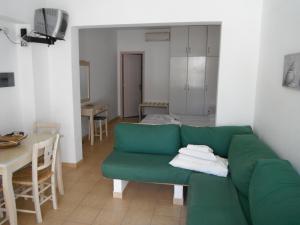 a living room with a green couch and a table at Mandorla Apartments in Lardos