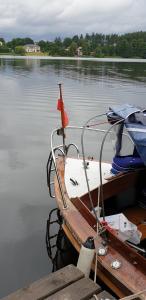 un petit bateau attaché à un quai dans l'eau dans l'établissement Przystań Kapitanat, à Szczecinek