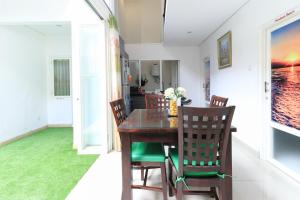 a dining room with a wooden table and chairs at Donata House in Jimbaran