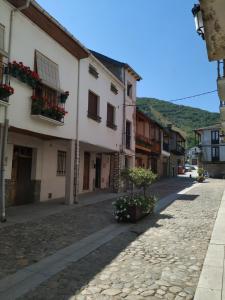 an empty street in a town with buildings at Camino Real in Molinaseca