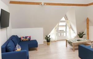 a living room with a blue couch and a table at Vila G Palanga in Palanga