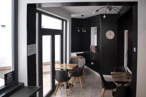 阿爾梅里亞的住宿－BUTIK Almería Centro，一间拥有黑色墙壁和桌椅的用餐室
