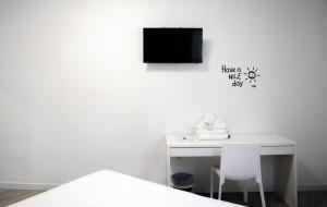 un escritorio blanco con TV en la pared en BUTIK Almería Centro, en Almería