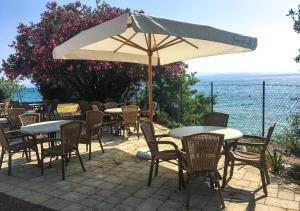 a group of tables and chairs with an umbrella at Sivinos Camping Boutique in Manerba del Garda