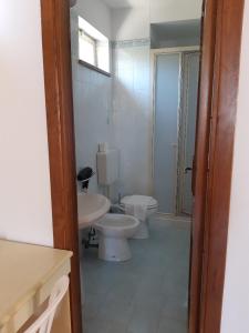 カンネートにあるBaia Unciの白いバスルーム(トイレ、シンク付)