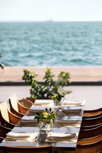 a table with plates and flowers on top of the ocean at Daios Luxury Living in Thessaloniki
