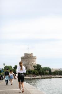 a woman walking down a sidewalk in front of a castle at Daios Luxury Living in Thessaloniki