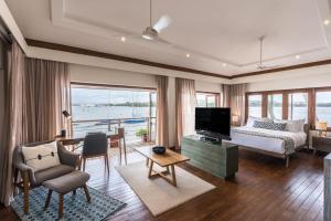 VeremにあるStayVista at Villa Kinara The Luxury Collectionのベッドルーム1室(ベッド1台付)、リビングルーム(テレビ付)