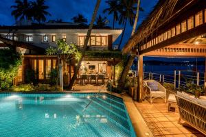 a house with a swimming pool at night at StayVista at Villa Kinara The Luxury Collection in Old Goa