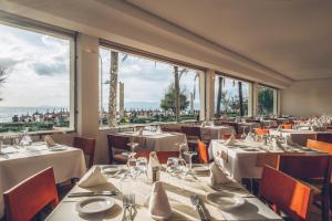 restauracja z białymi stołami, krzesłami i oknami w obiekcie AYA Seahotel - Adults Only w mieście Playa de Palma