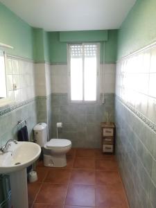 een badkamer met toilet, wastafel en raam bij El Arrecorzo by #cherrygredos in El Arenal