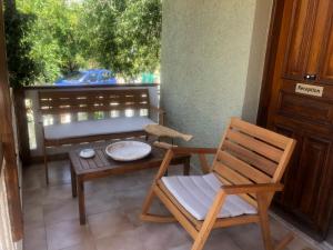 a porch with a chair and a table and a bench at Nicolas Beach in Palaiochora