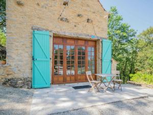 a table and chairs in front of a building with blue doors at Mansion in Lavercanti re with Private Pool in Lavercantière