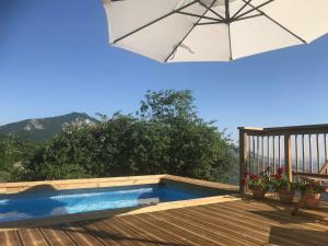 a pool on a deck with an umbrella at Belvilla by OYO Casa grande in Corvara