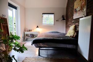 a bedroom with a bed and a brick wall at Onder de Appelboom in Garminge