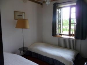 a bedroom with two beds and a window at Gite Des Etangs in Paulnay