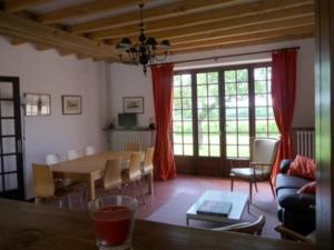 uma sala de estar com uma mesa e uma sala de jantar em Gite Des Etangs em Paulnay