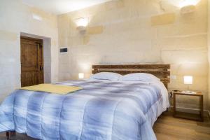 a bedroom with a large bed with a blue comforter at Casal Dragone in Matera