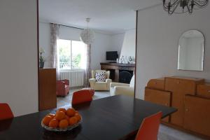 a dining room and living room with a table and chairs at The Yellow House in Mataelpino
