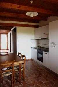 a kitchen with a table and chairs in a room at La Ripa Del Drago in Bibbona