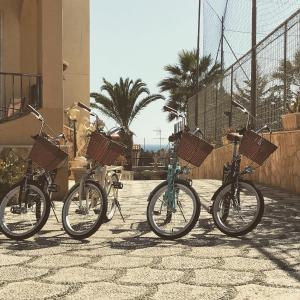 quattro biciclette parcheggiate di fila con dei cestini sopra. di B&B Villa Marinetti a Gela