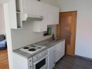 a white kitchen with a stove and a sink at Apartment Doris in Kostrena