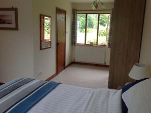 sypialnia z łóżkiem i oknem w obiekcie Meadowview w mieście Cullompton