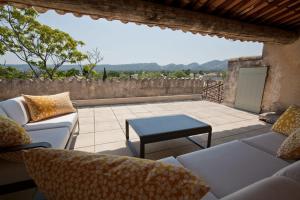 a patio with couches and a table and a view at L'Oiseau Qui Chante in Eygalières