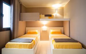 twee bedden in een kleine kamer met gele bedden bij Pep Ventura in Figueres