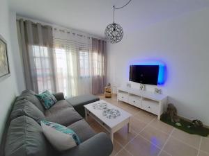 ein Wohnzimmer mit einem Sofa und einem TV in der Unterkunft Casa Cactus in Pájara