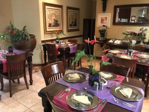 a dining room with tables and chairs with purple table settings at Le Cozmo Guesthouse in Johannesburg