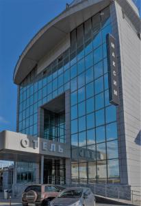 un edificio con coches estacionados frente a él en Maksim Hotel, en Yekaterinburg