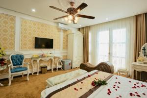 um quarto com uma cama e uma mesa com rosas em King's Hotel Yên Hòa em Hanói