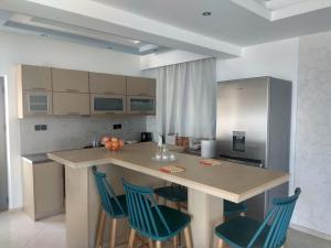 a kitchen with a large island with blue chairs at Villa Gusta in Thólos