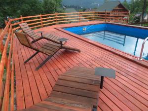 a chair sitting on a deck next to a swimming pool at Забаганка in Mykulychyn