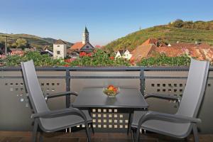 Schelingen的住宿－Zieglers Ferienwohnungen，阳台上的桌椅和一碗水果