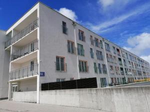 - un grand bâtiment blanc avec des fenêtres sur le côté dans l'établissement Family Homes - Apartamenty Sonoma, à Władysławowo