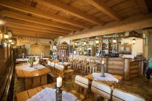 een restaurant met houten tafels en stoelen en een bar bij Karczma Taberska in Kolesin