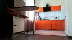 a kitchen with orange cabinets and a table in it at пр. Дмитрия Яворницкого Апартаменты in Dnipro